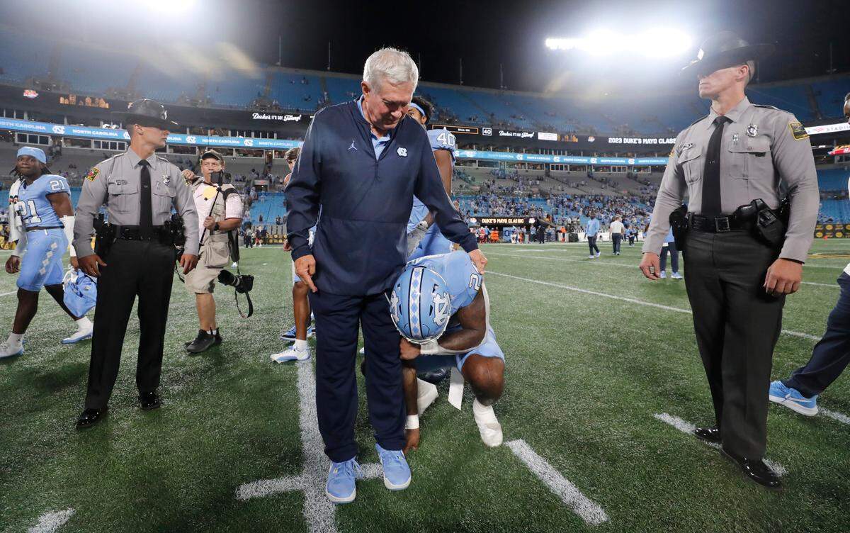 North Carolina head coach Mack Brown checks on running back British Brooks (24), who was brought to tears after UNC’s 31-17 victory over South Carolina in the Duke’s Mayo Classic at Bank of America Stadium in Charlotte, N.C., Saturday, Sept. 2, 2023.