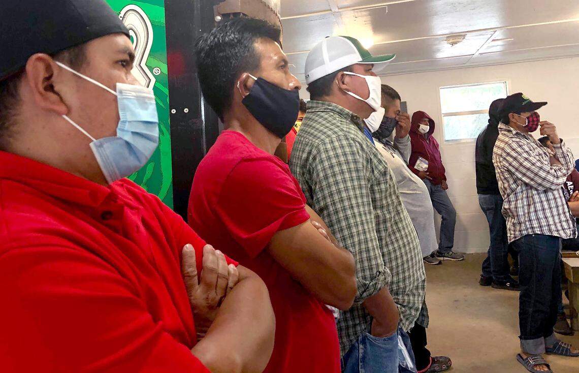 Seasonal migrant farmworkers with temproary H-2A work visas listen to outreach workers from The N.C. Farmworkers’ Project provide education the COVID-19 vaccine during a visit to their housing in Four Oaks, N.C on Sunday, April 4, 2021.