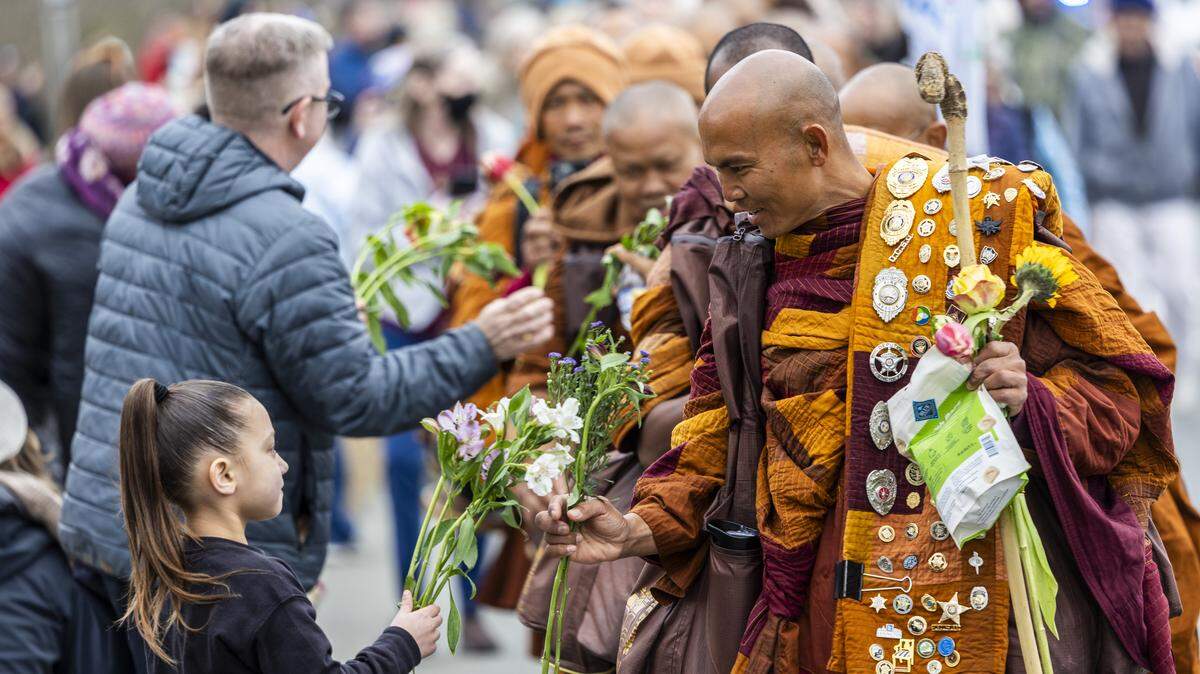 A small procession of Buddhist monks walks along U.S. Highway 64 west of Pittsboro on Thursday, Jan. 22, 2026, as hundreds of onlookers line the highway to welcome them. The monks are making a 2,300-mile pilgrimage from Texas to Washington, D.C., as part of the “Walk for Peace,” an effort to promote peace, compassion and national unity.