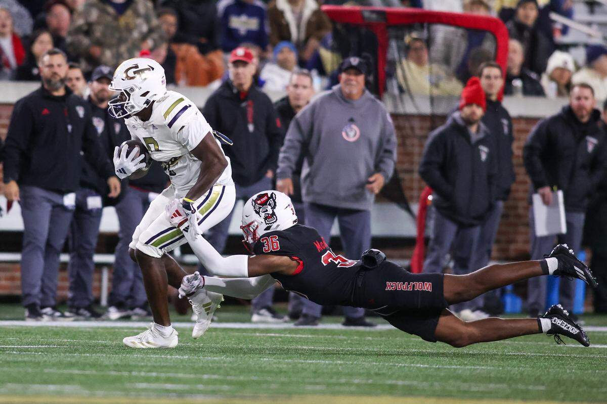 Nov 21, 2024; Atlanta, Georgia, USA; Georgia Tech Yellow Jackets wide receiver Avery Boyd (9) is tackles by North Carolina State Wolfpack linebacker Kelvon McBride (36) in the first quarter at Bobby Dodd Stadium at Hyundai Field. Mandatory Credit: Brett Davis-Imagn Images