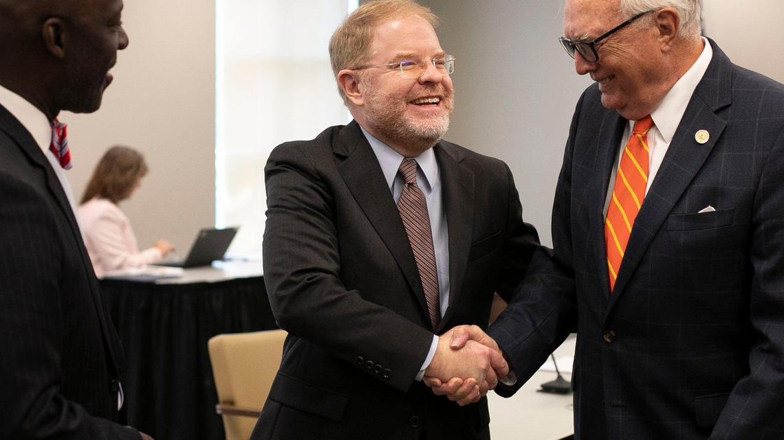 Peter Hans shakes hands with then Board of Governors member Leo Daughtry following Hans’ election as UNC System president on June 19, 2020 in Chapel Hill, N.C.