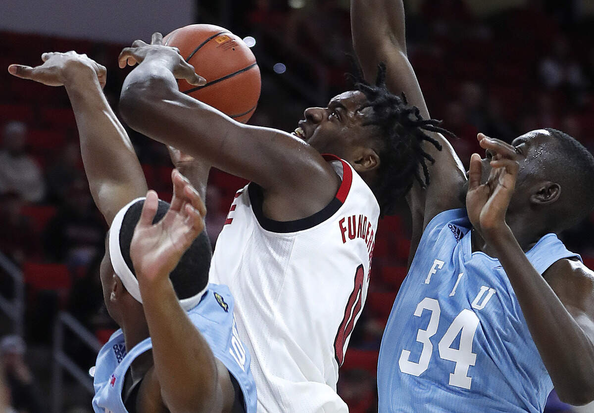 N.C. State’s DJ Funderburk (0) is fouled as FIU’s Osasumwen Osaghae (34) and Eric Lovett (4) defend during the first half of N.C. State’s game against Florida International at PNC Arena in Raleigh, N.C., Wednesday, Nov. 13, 2019.
