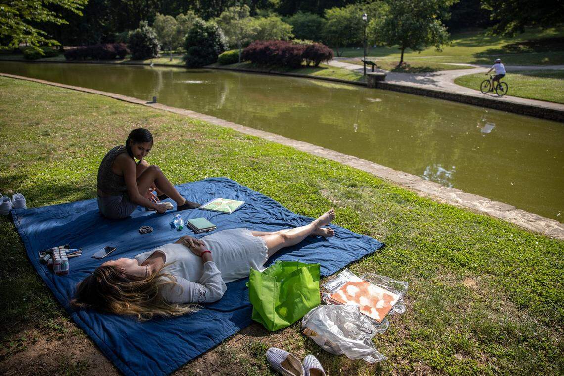 Aniyah Buckner, left, and Stella Ervin seek relief from the heat under the shade of the trees at Freedom Park in Charlotte, N.C., on May 24, 2021. The first heat wave of 2022 is expected to “engulf” the region next week, the NWS warned.