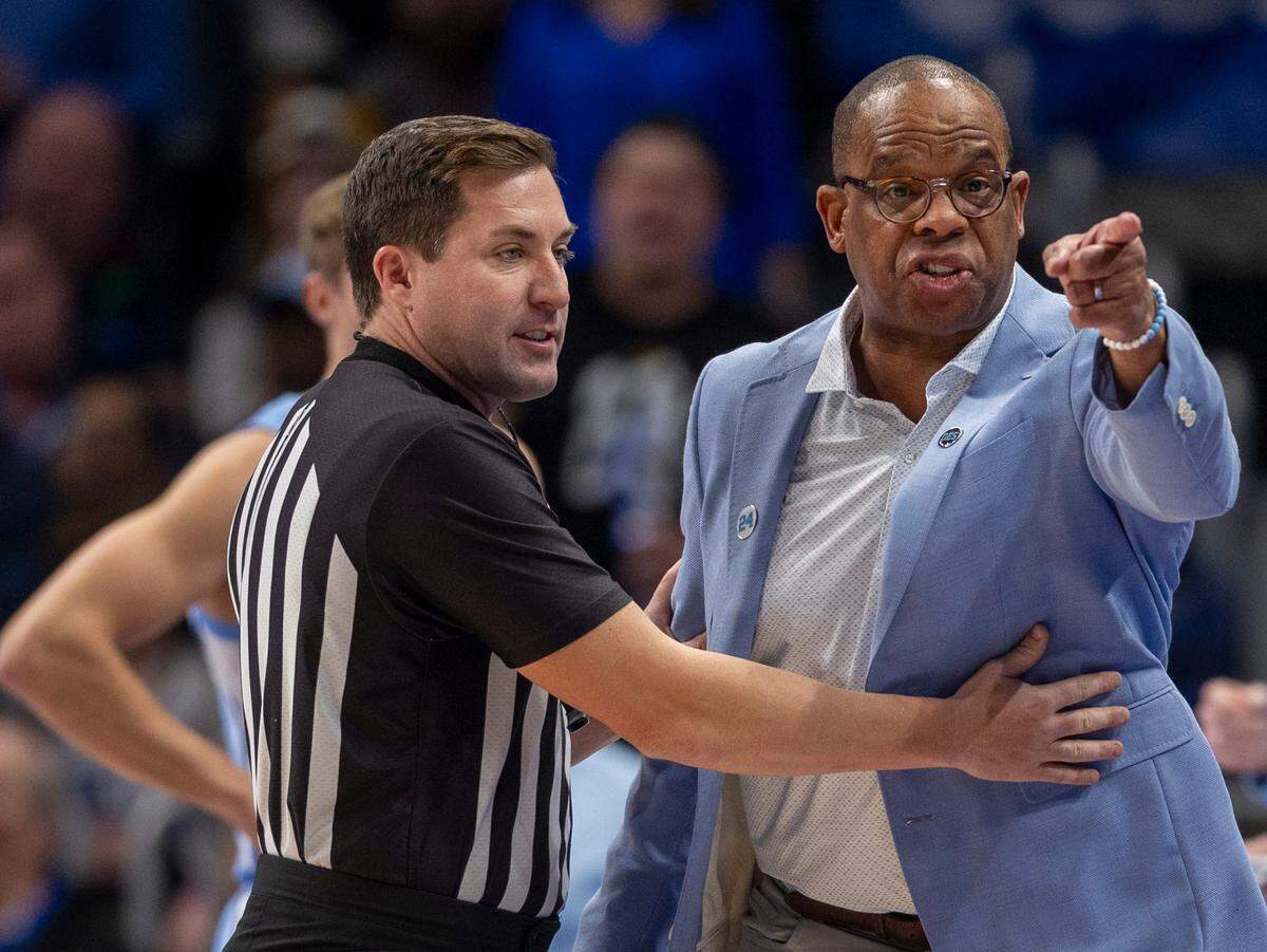 Official Kelly Pfeifer restrains North Carolina coach Hubert Davis reacts after a technical foul on Paxson Wojcik (8) during the first half against Kentucky on Saturday, December 16, 2023 at State Farm Arena in Atlanta, Georgia.