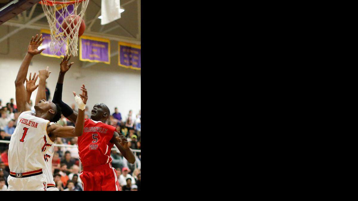Orangeville Prep's Matur Maker (5) is defended by Wesleyan Christian's Harry Giles (1) Holiday Invitational Tournament at Broughton High School's Holliday Gymnasium Tuesday in Raleigh.
