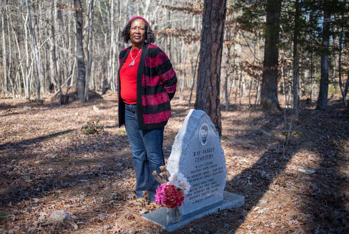Retired Judge Beverly Scarlett poses for a portrait in Hillsborough, N.C. at the entrance to the Ray family cemetery on Wednesday, Feb. 15, 2022. The entrance marker displays a photograph of Sallie Ray Harris, Scarlett’s maternal great-grandmother.