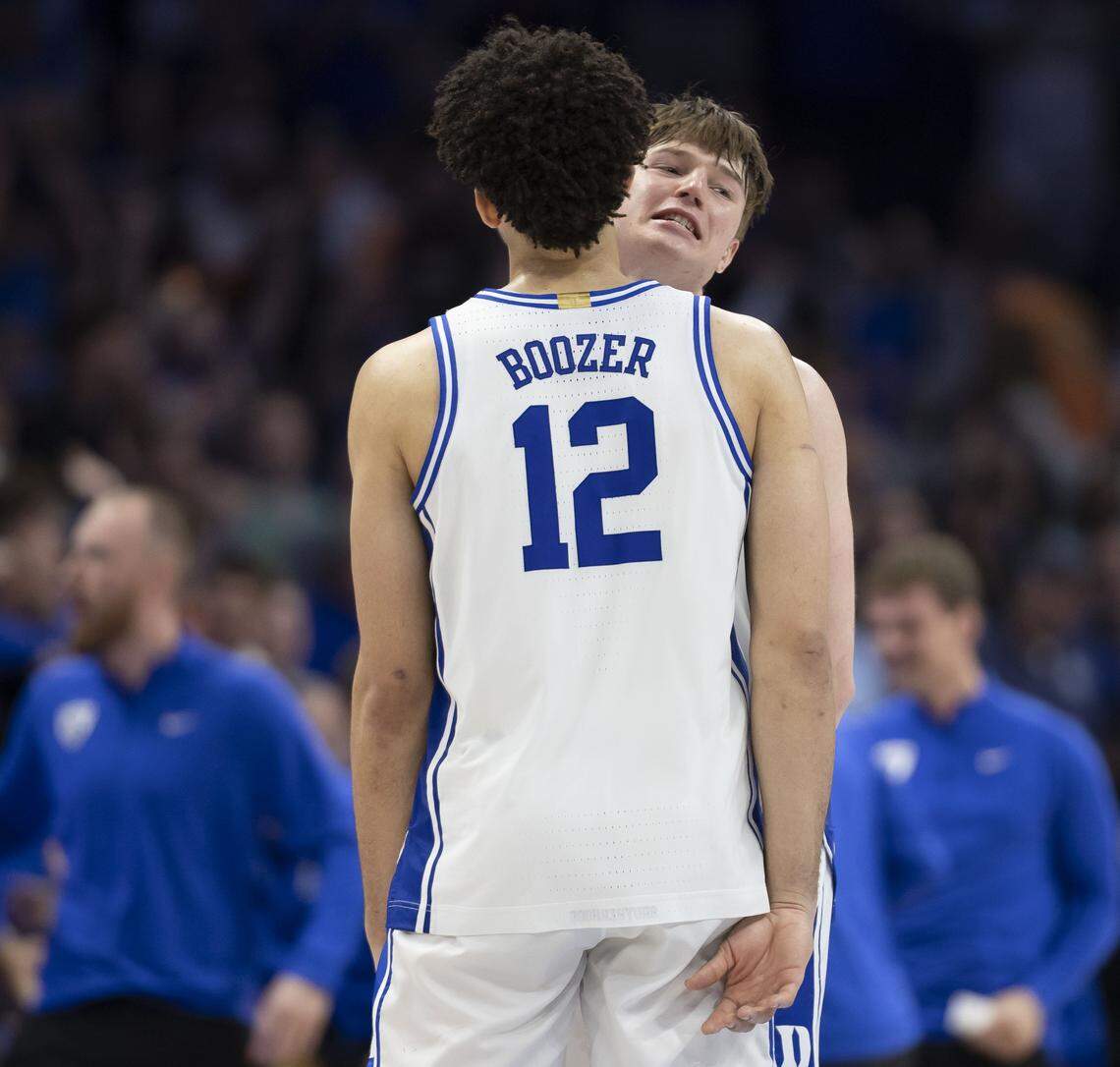 Duke guard Nikolas Khamenia (14) chest bumps teammate Cameron Boozer as they celebrate the Blue Devils’ 74-70 victory over Virginia, clinching the ACC Tournament Championship, on Saturday, March 14, 2026 at Spectrum Center in Charlotte, N.C.
