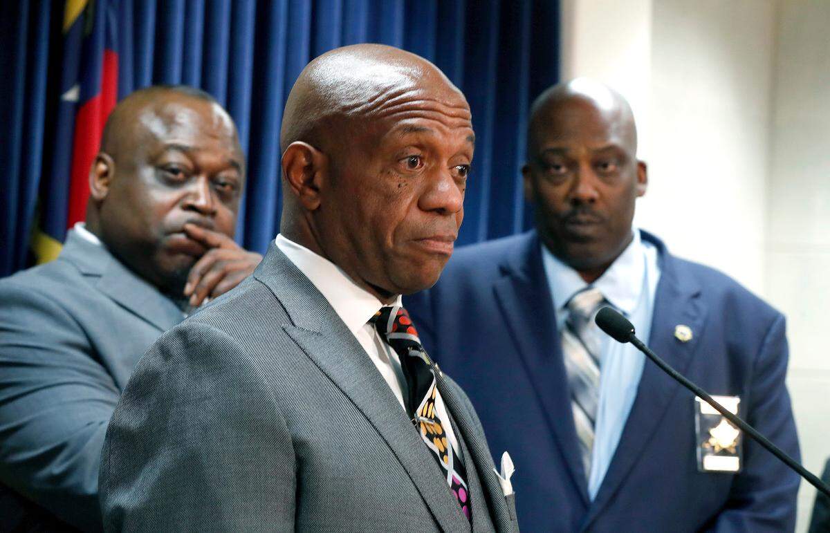 Wake County Sheriff Gerald Baker, left, and Buncombe County Sheriff Quentin Miller, right, listen as Mecklenburg County Sheriff Garry McFadden speaks against House Bill 370 during a press conference at the Legislative Building in Raleigh, N.C., Wednesday, June 19, 2019.