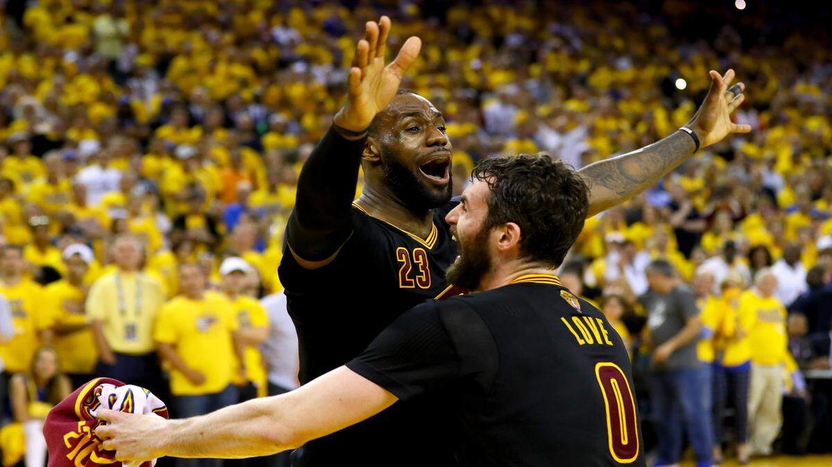 LeBron James and Kevin Love of the Cleveland Cavaliers celebrate after defeating the Golden State Warriors 93-89 in Game 7 of the 2016 NBA Finals. 