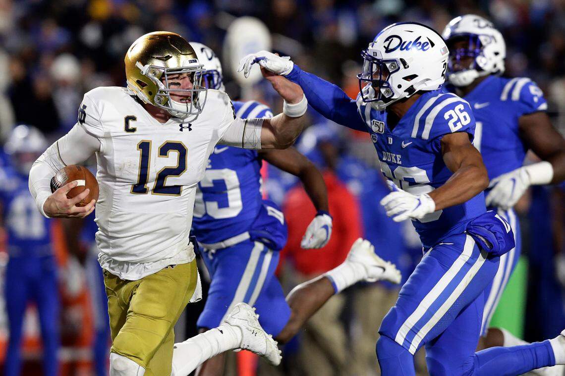 Notre Dame quarterback Ian Book (12) runs the ball while Duke safety Michael Carter II (26) chases during their game in Durham, N.C., Saturday, Nov. 9, 2019.