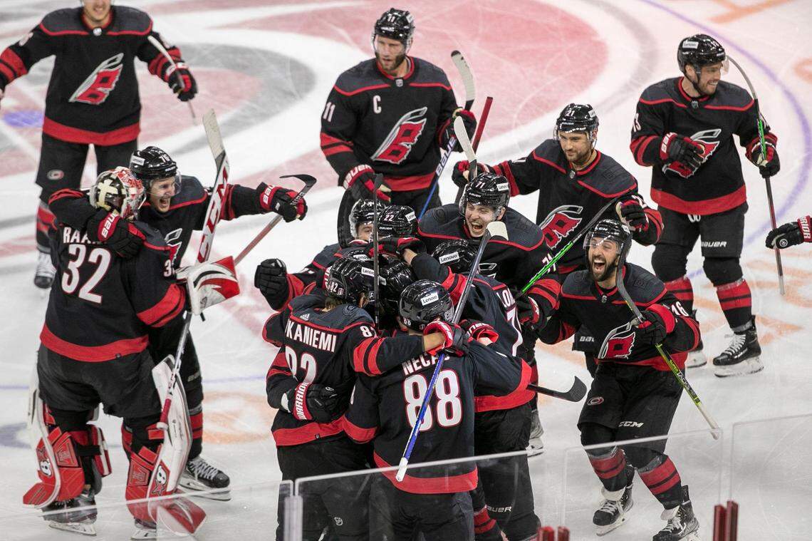Carolina Hurricanes Ian Cole (28) is surrounded by his teammates after scoring the game winning goal in overtime against the New York Rangers on Wednesday, May 18, 2022 during game one of the Stanley Cup second round at PNC Arena in Raleigh, N.C.