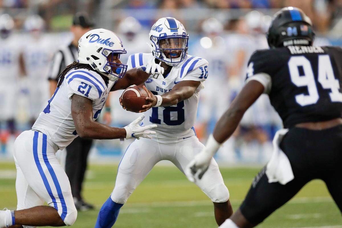Duke quarterback Quentin Harris (18) hands off to running back Mataeo Durant (21) as Middle Tennessee defensive end Tyshun Render rushes in the first half of an NCAA college football game Saturday, Sept. 14, 2019, in Murfreesboro, Tenn.