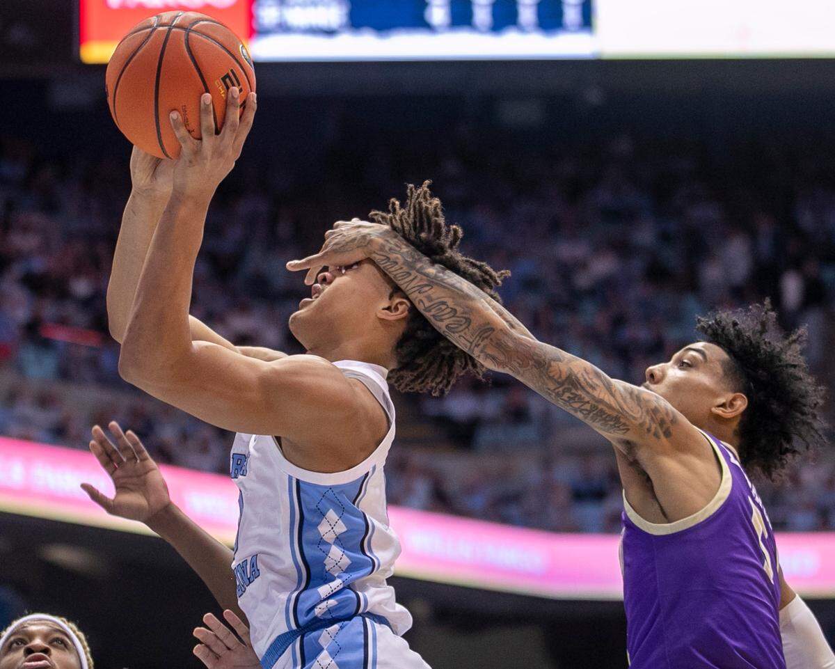 James Madison’s Terrence Edwards (5) fouls North Caroliona’s Seth Trimble (0) in the first half on Sunday, November 20, 2022 at the Smith Center in Chapel Hill, N.C.