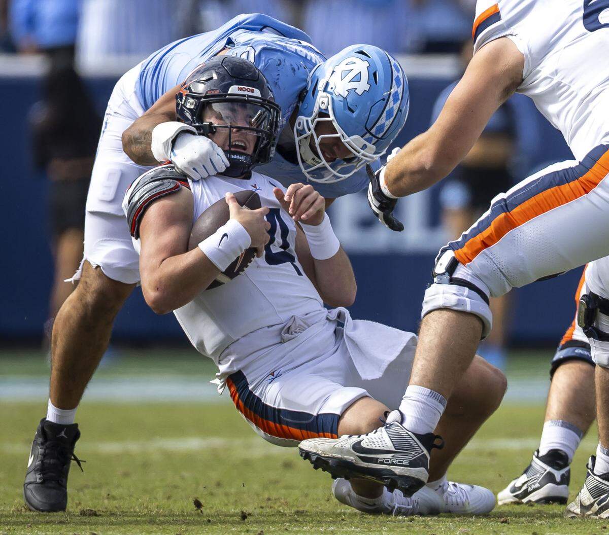 Virginia quarterback Chandler Morris (4) is sacked by North Carolina defensive lineman Melkart Abou Jaoude (9) for a six-yard loss in the third quarter on Saturday, October 25, 2025 at Kenan Stadium in Chapel Hill, N.C.