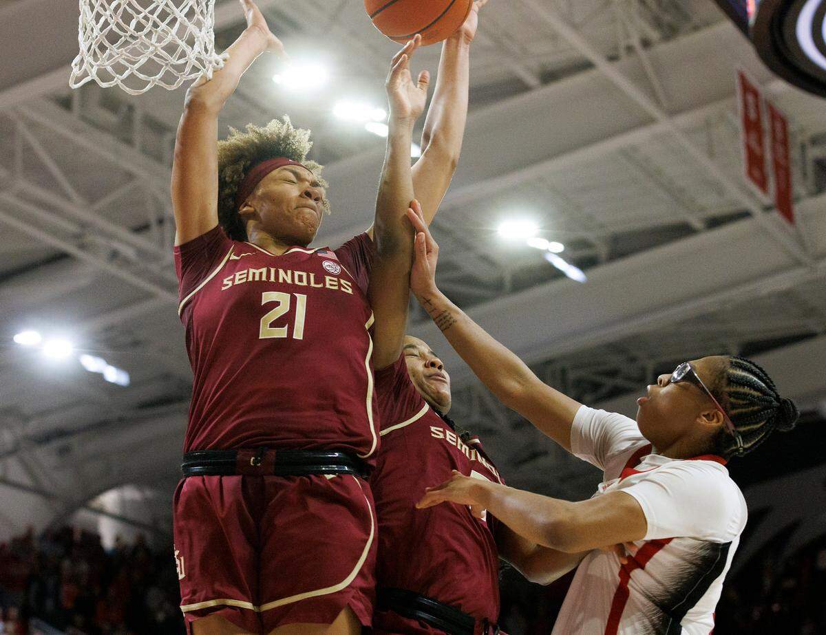 N.C. State’s Zoe Brooks puts up a shot over Florida State’s Makayla Timpson and Alexis Tucker during overtime of the Wolfpack’s 88-80 win on Thursday, Jan. 4, 2023, at Reynolds Coliseum in Raleigh, N.C.