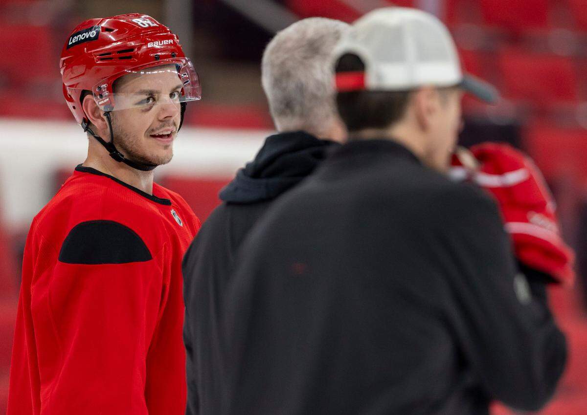 Carolina Hurricanes center Jesperi Kotkaniemi (82) talks with coaches Jeff Daniels and Rod Brind’Amour during practice on Friday, May 2, 2025 at Lenovo Center in Raleigh, N.C. Kotkaniemi injured his right eye during Game 5 against the New Jersey Devils.