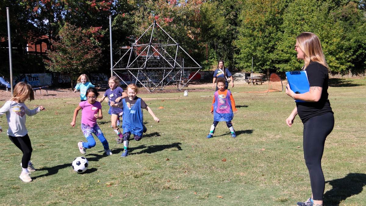 Anne Sutkowi-Hemstreet, founder and executive director of the Rainbow Collective for Change, watches children playing a game of gender-inclusive soccer at the Old North Durham Park, on Sunday, Oct. 22, 2023.