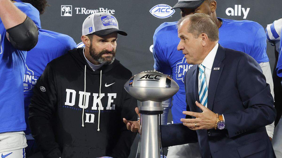 Duke head coach Manny Diaz (left) talks with ACC Commissioner Jim Phillips prior to the trophy presentation after the Blue Devils’ 27-20 overtime win over Virginia in the ACC Football Championship on Saturday, Dec. 6, 2025, at Bank of America Stadium in Charlotte, N.C.