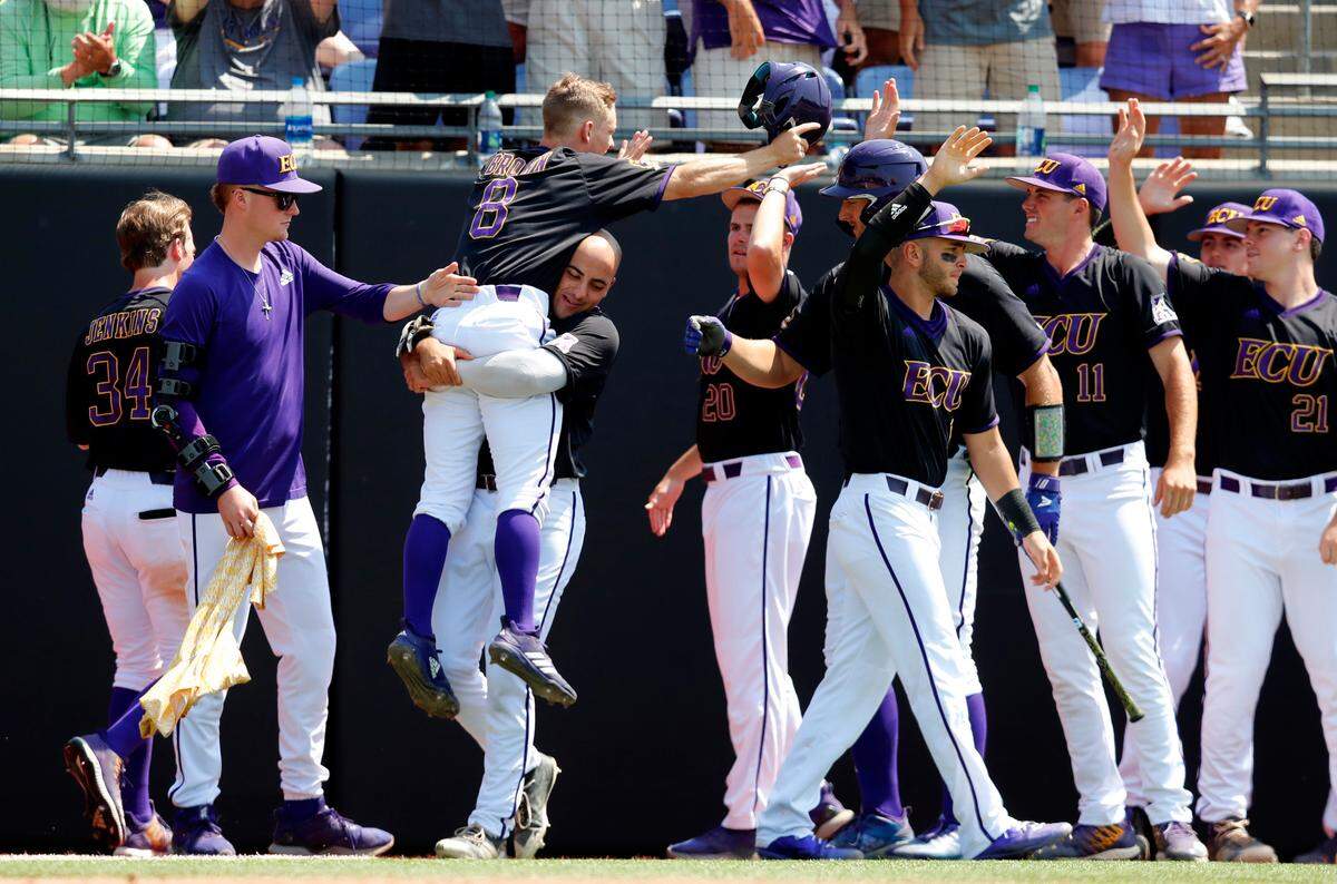 ECU’s Turner Brown (8) is carried by Jake Kuchmaner (29) as he celebrates scoring in the fifth inning during East Carolina’s game against Campbell in the Greenville Regional at Clark-LeClair Stadium in Greenville, N.C., Monday, June 3, 2019.