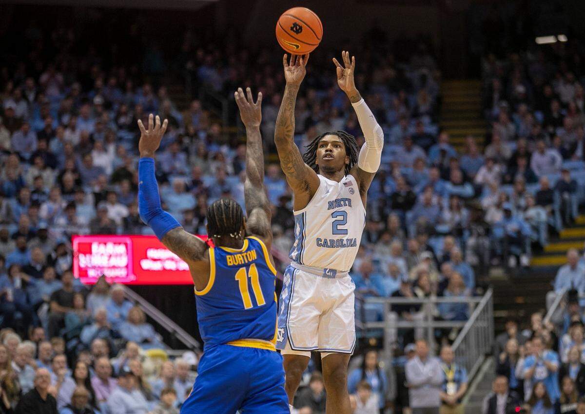 North Carolina’s Caleb Love (2) launches a three-point shot over Pittsburgh’s Jamarius Burton (11) during the first half on Wednesday, February 1, 2023 at the Smith Center in Chapel Hill, N.C.
