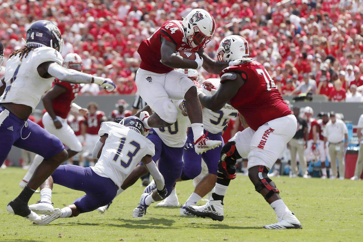 N.C. State running back Bam Knight (24) hurdles over Western Carolina defensive back Ronald Kent Jr. (13) during the first half of N.C. State’s game against Western Carolina at Carter-Finley Stadium in Raleigh, N.C., Saturday, Sept. 7, 2019.