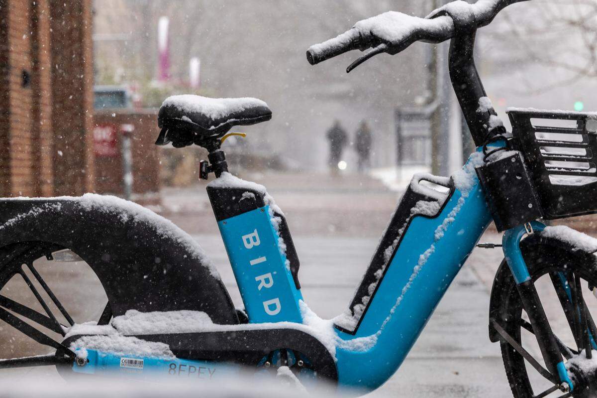 A rental bicycle begins to accumulate snow near UNC-Chapel Hill on Wednesday, Feb. 19, 2024.