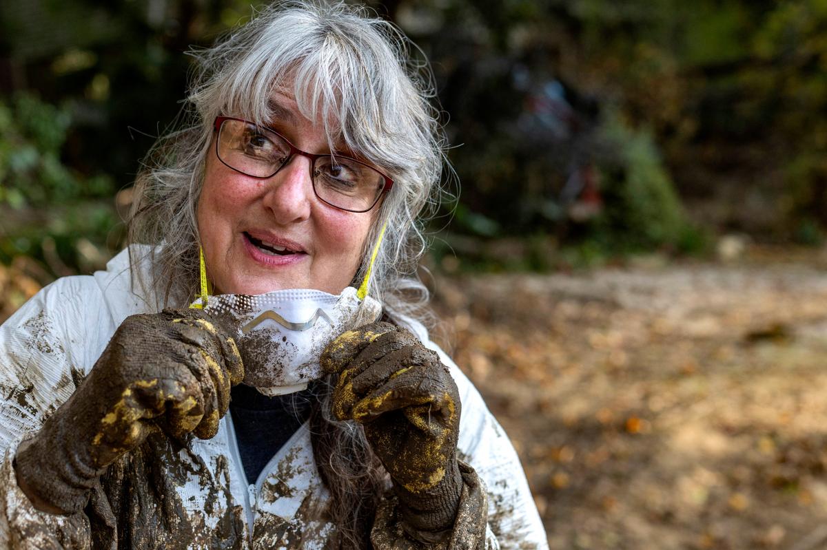 Susan Figetakis is covered with thick mud as he works to clean out her home, flooded by the Green River during Hurricane Helene, on Monday, October 7, 2024 near Saluda, N.C.