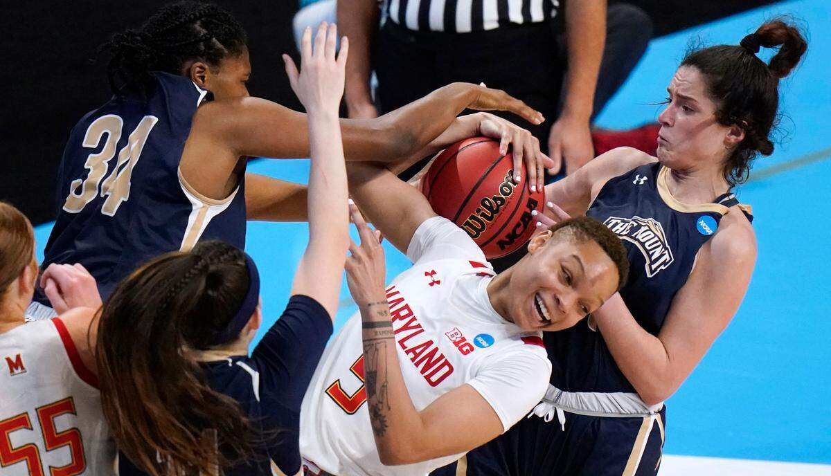 Maryland forward Alaysia Styles (5) fights for a rebound with Mount St. Mary’s guard Bridget Birkhead (11), center Rebecca Lee (34) and guard Kendall Bresee, right, during the second half of a college basketball game in the first round of the women’s NCAA tournament at the Alamodome in San Antonio, Monday, March 22, 2021. (AP Photo/Eric Gay)
