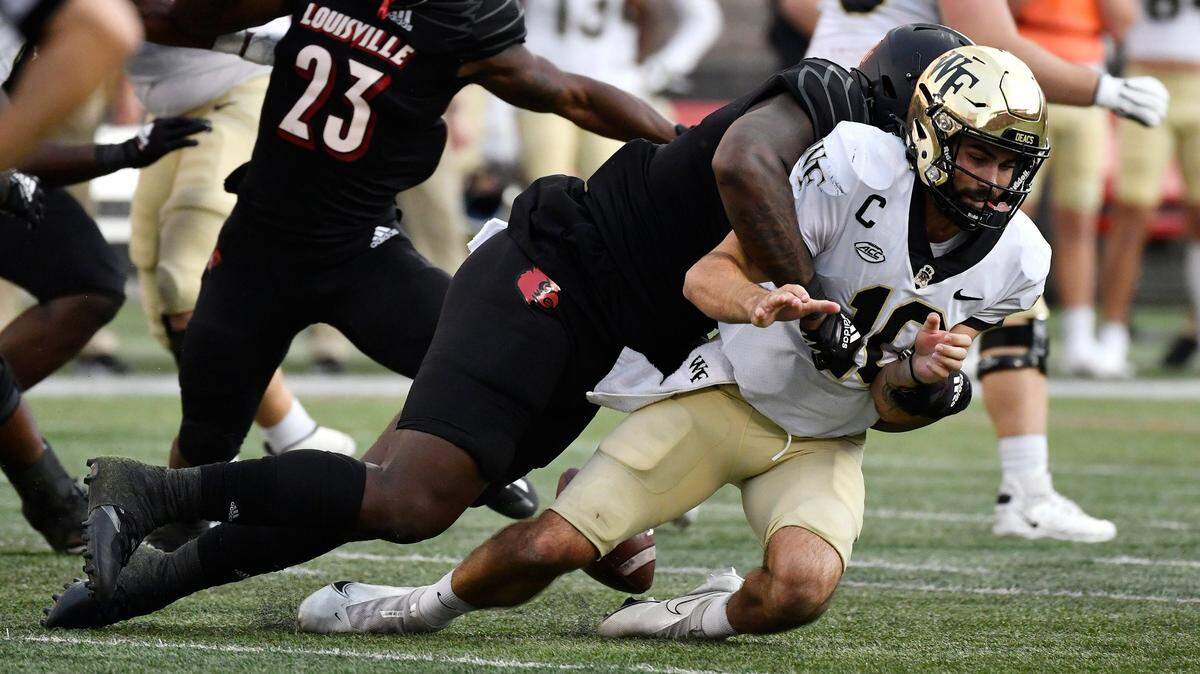 Wake Forest quarterback Sam Hartman loses the football as he is sacked by Louisville defensive lineman Caleb Banks during the second half of an NCAA college football game in Louisville, Ky., Saturday, Oct. 29, 2022. Louisville won 48-21. (AP Photo/Timothy D. Easley)