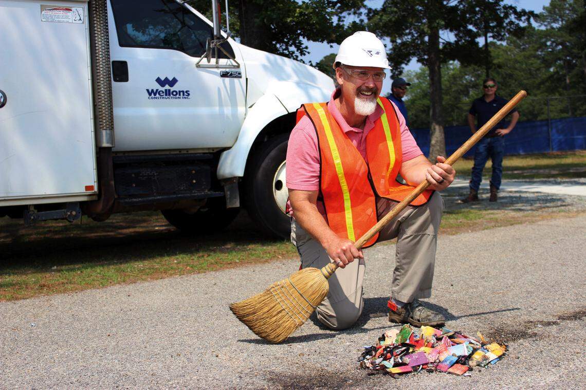 Gary Pierce kneels by a pile of skeletal vapes, crushed and ready for the trash.