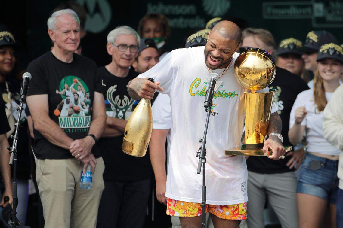 Milwaukee Bucks’ P.J. Tucker yells to the crowd as he holds the NBA Championship Trophy during a parade celebrating the team’s basketball championship win, Thursday, July 22, 2021, in Milwaukee.