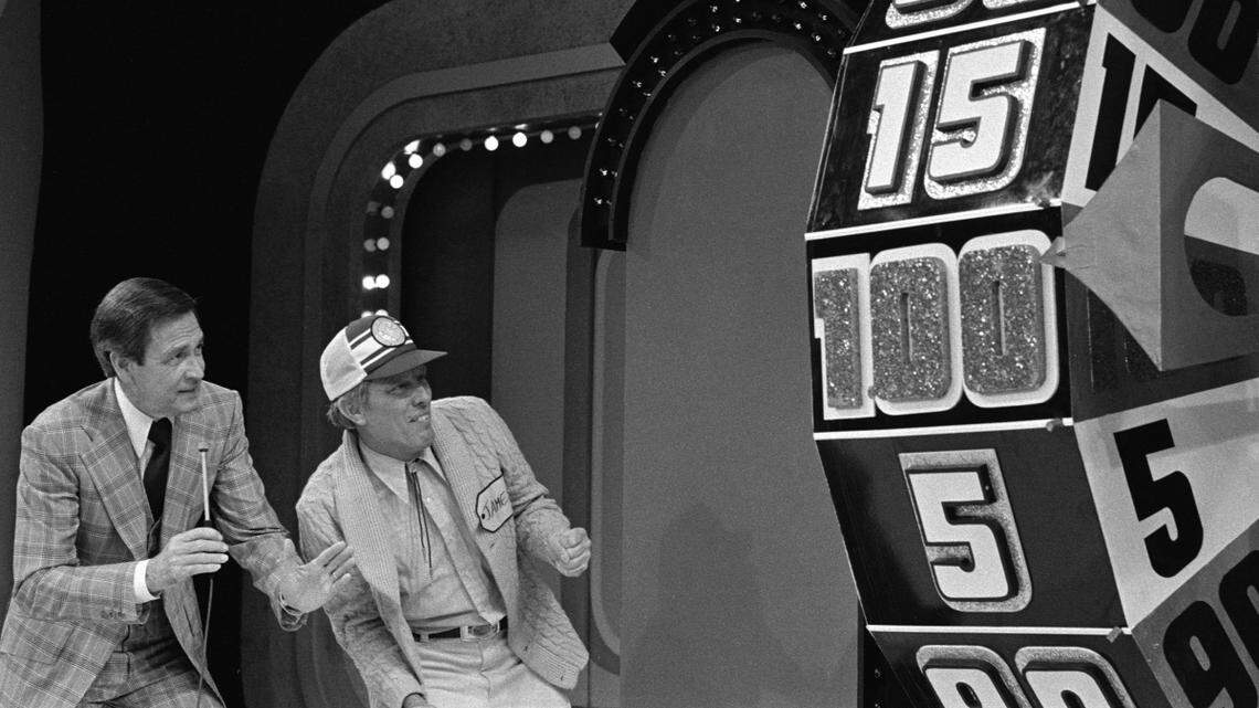In this image from February 8, 1978, host Bob Barker and a contestant named James watch the big wheel during the Showcase Showdown on an episode of “The Price is Right.” The series is celebrating 50 years on the air with a special airing Sept. 30, 2021, on CBS.