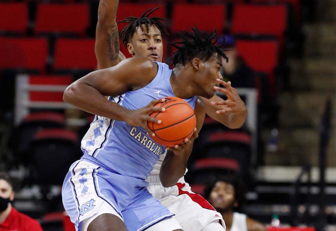 N.C. State’s Manny Bates (15) guards North Carolina’s Day’Ron Sharpe (11) during the first half of N.C. State’s game against UNC at PNC Arena in Raleigh, N.C., Tuesday, December 22, 2020.