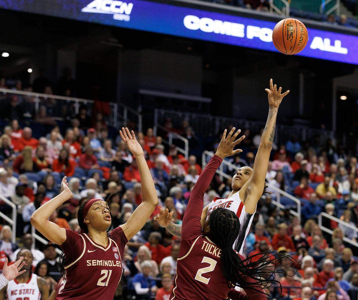 N.C. State’s Aziaha James shoots over Florida State’s Makayla Timpson and Alexis Tucker during the second half of the Wolfpack’s 69-43 win in the ACC Tournament semifinals on Saturday, March 9, 2024, at Greensboro Coliseum in Greensboro, N.C.