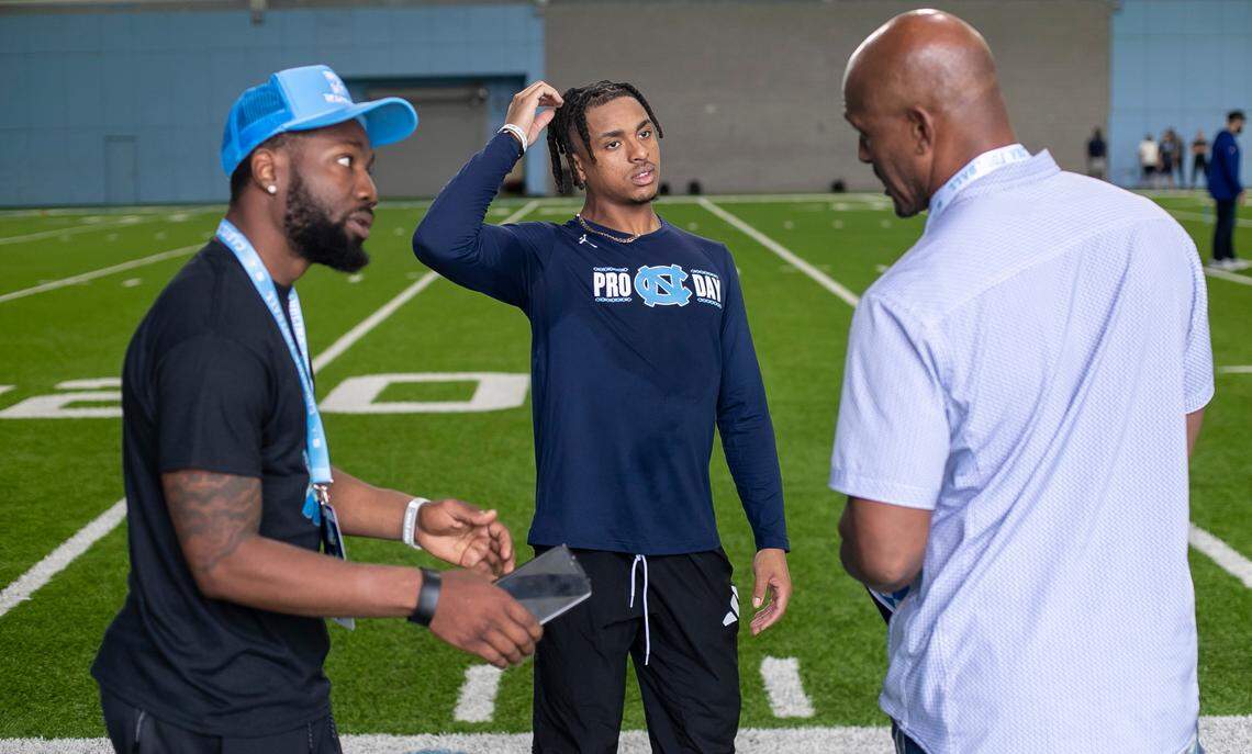 North Carolina’s Josh Downs talks with his father Gary Downs, right and trainer Stephon Brown during the NFL Pro Day on Monday, March 27, 2023 in Chapel Hill, N.C.