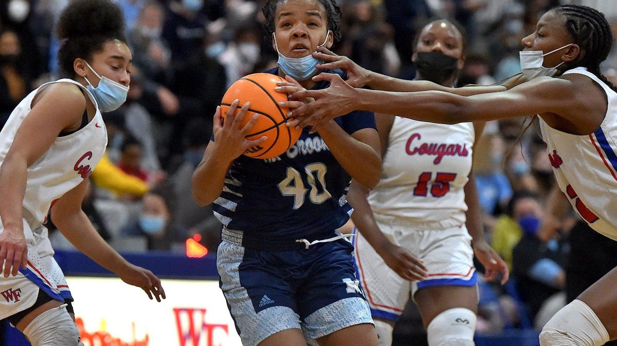 Millbrook’s Ivory Galloway (40) drives to the basket between Wake Forest’s Shayla Rodriquez (5) and Amina Miles (22) during the first half. The Wake Forest Cougars and the Millbrook Wildcats met in a basketball game in Wake Forest, N.C. on February 8, 2022.