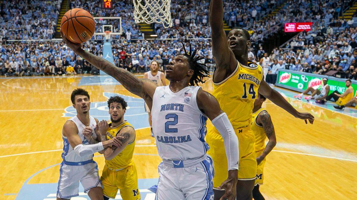 North Carolina’s Caleb Love (2) breaks to the basket against Michigan’s Moussa Diabate (14) in the first half on Wednesday, December 1, 2021 at the Smith Center in Chapel Hill, N.C.