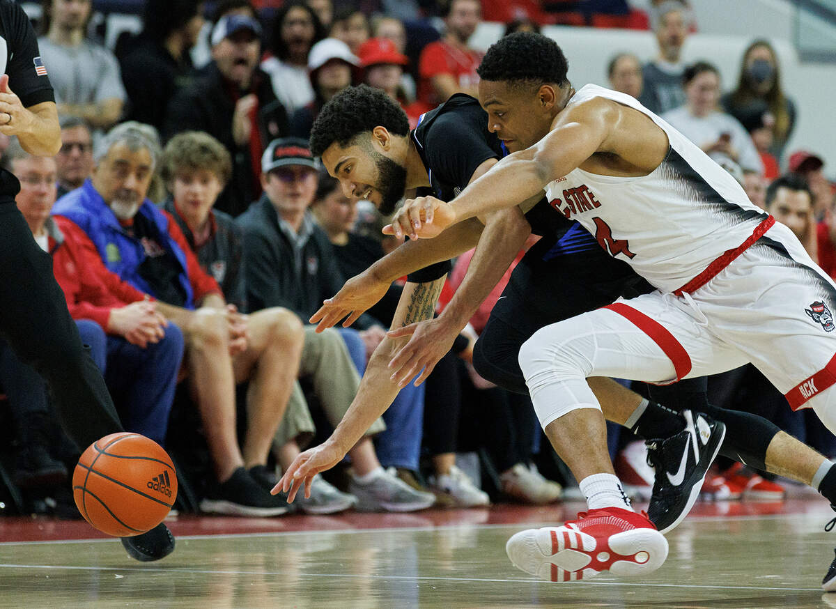 N.C. State’s Casey Morsell and Saint Louis’ Michael Meadows Jr. dive for a loose ball during the second half of the Wolfpack’s 82-70 win on Wednesday, Dec. 20, 2023, at PNC Arena in Raleigh, N.C.