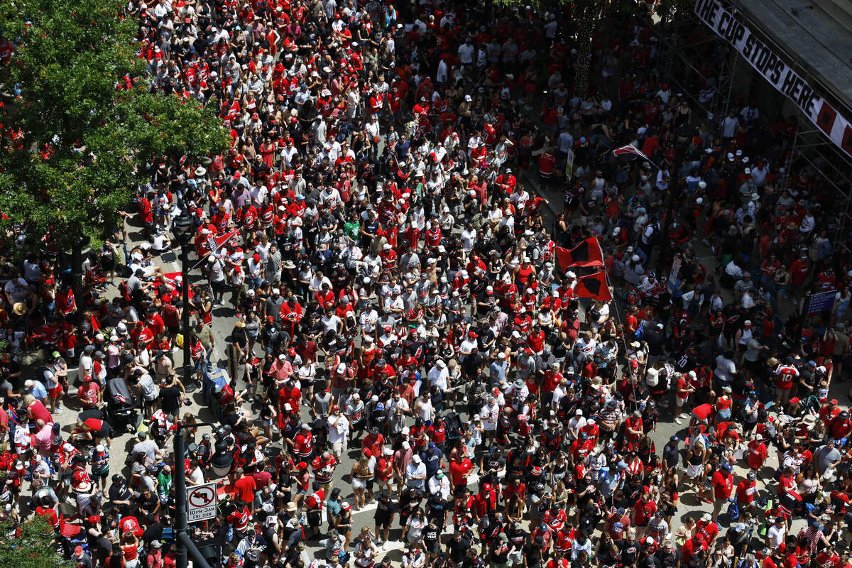 Thousands of fans surge into Fayetteville Street to follow the parade to a rally at One City Plaza.