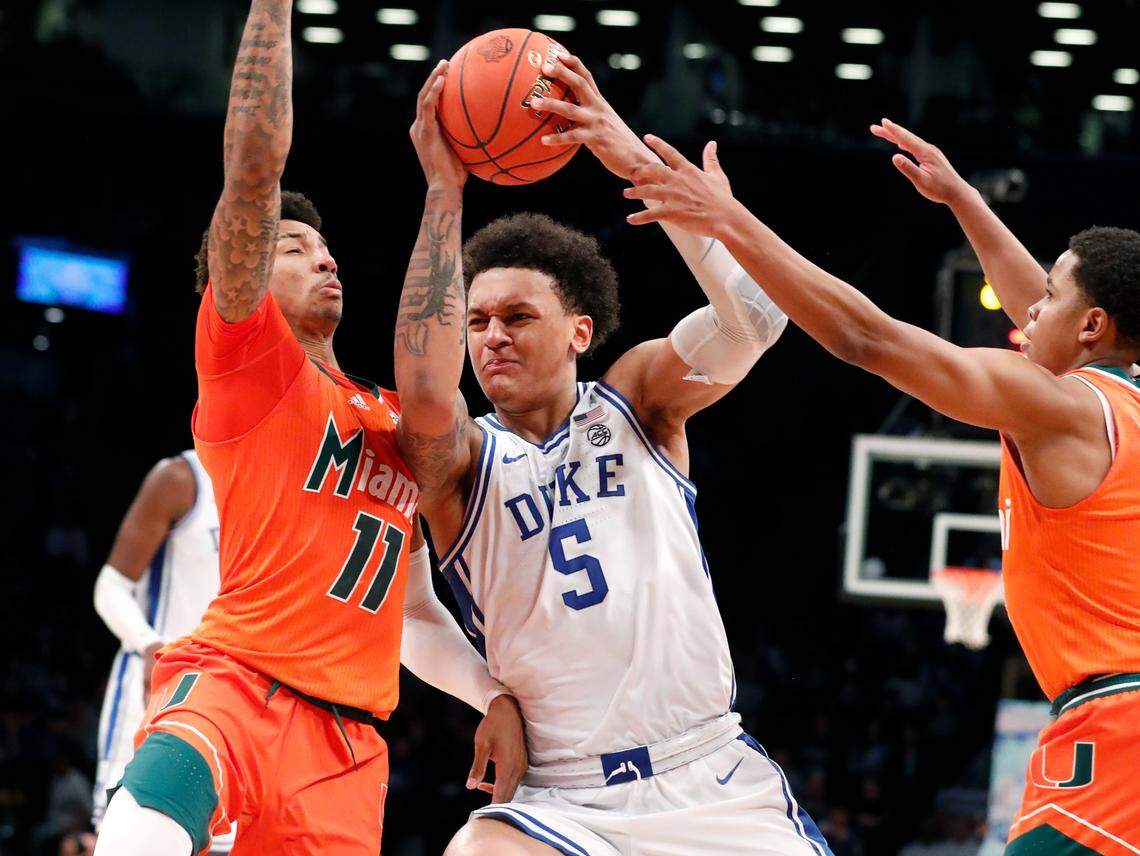 Duke’s Paolo Banchero (5) drives between Miami’s Jordan Miller (11) and Charlie Moore (3) during the second half of Duke’s 80-76 victory over Miami in the semifinals of the ACC men’s basketball tournament at the Barclays Center in Brooklyn, N.Y., Friday, March 11, 2022.