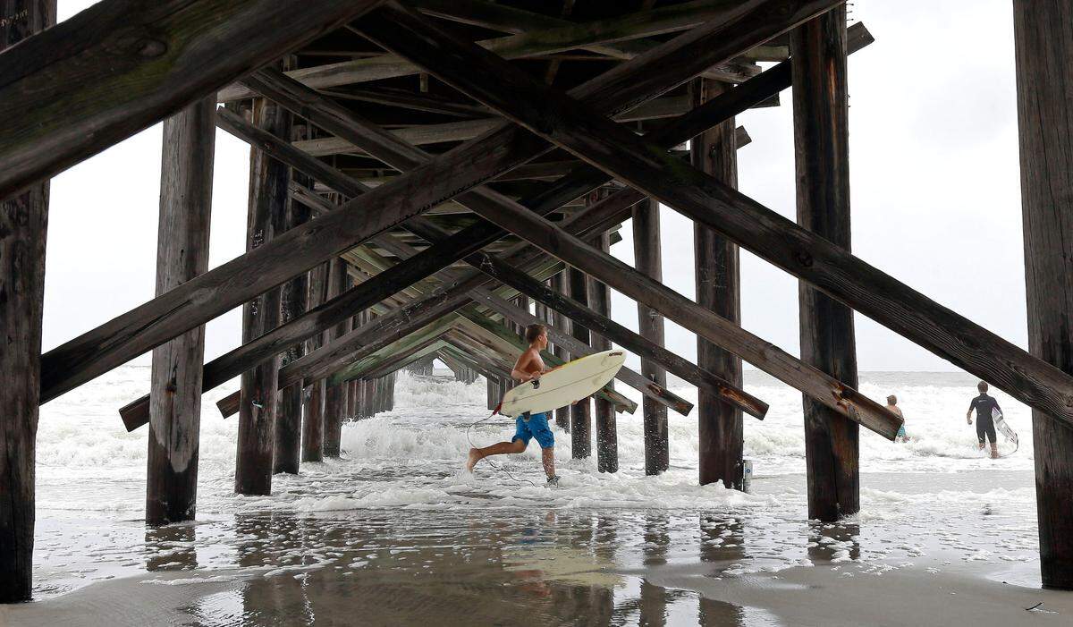 Surfers take advantage of heavy surf at the pier in Ocean Isle Beach, N.C., in this file photo.