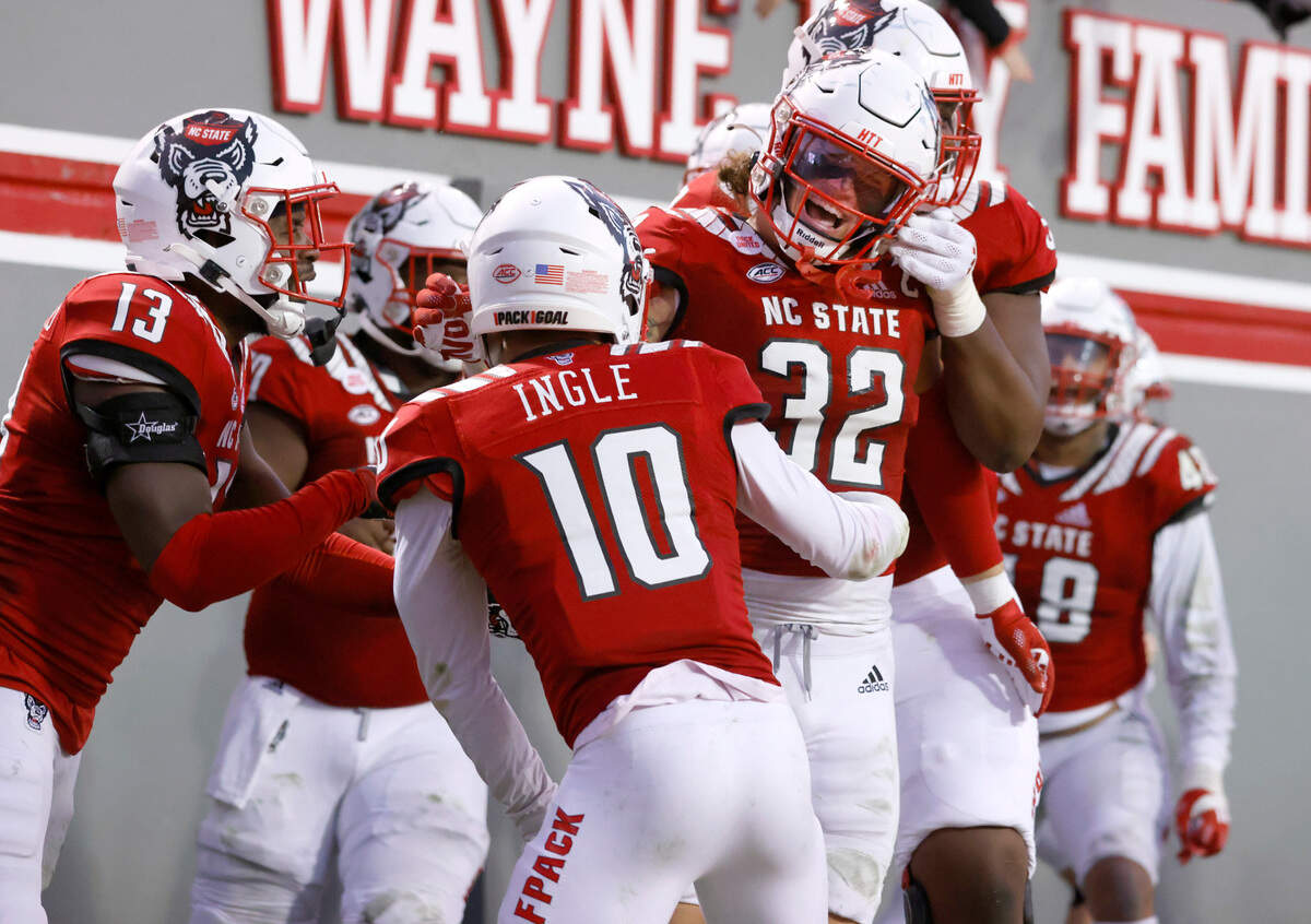 N.C. State linebacker Drake Thomas (32) celebrates with teammates after returning an interception for a touchdown during the first half of N.C. State’s game against Syracuse at Carter-Finley Stadium in Raleigh, N.C., Saturday, Nov. 20, 2021.