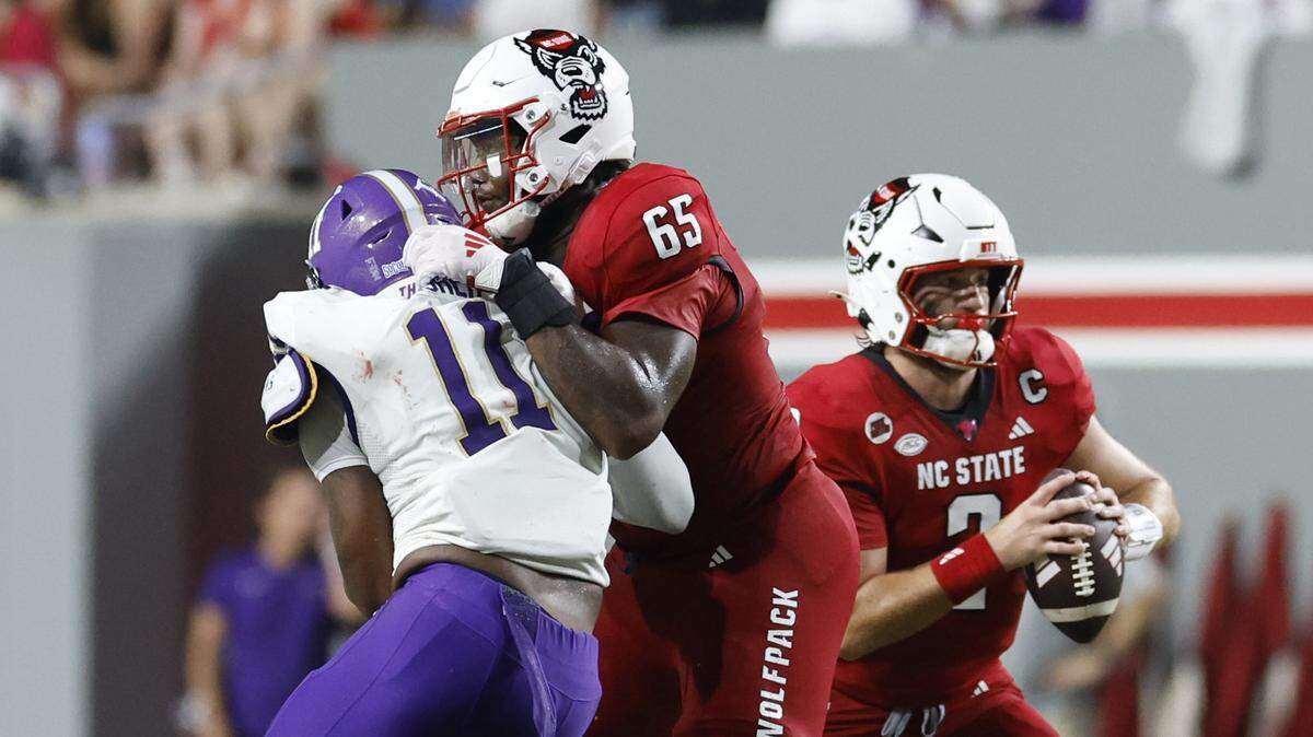 N.C. State offensive tackle Jacarrius Peak (65) blocks Western Carolina defensive lineman Caleb Fisher (11) as quarterback Grayson McCall (2) looks for receivers during the second half of N.C. State’s 38-21 victory over Western Carolina at Carter-Finley Stadium in Raleigh, N.C., Thursday, August 29, 2024.