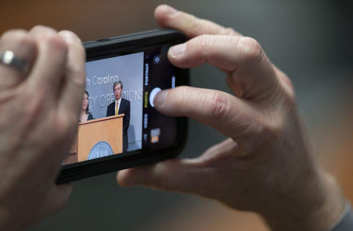 Mike Sprayberry, Director of Emergency Management, takes a photograph of North Carolina Governor Roy Cooper during a press briefing on COVID-19 on Friday, May 22, 2020 at the Emergency Operations Center in Raleigh, N.C. 