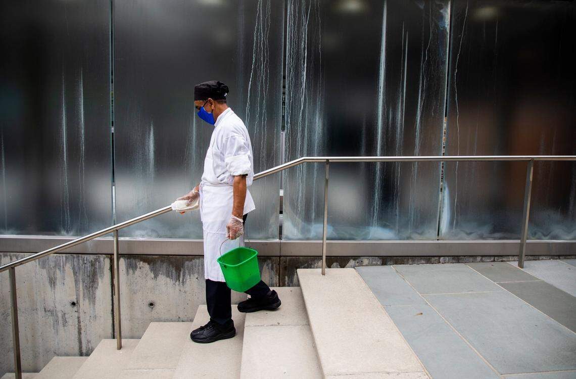 Wearing a mask to prevent the spread of COVID-19, staff member Munwar Ahmad sanitizes surfaces on campus at Duke University on Tuesday, Sept. 1, 2020, in Durham, N.C.