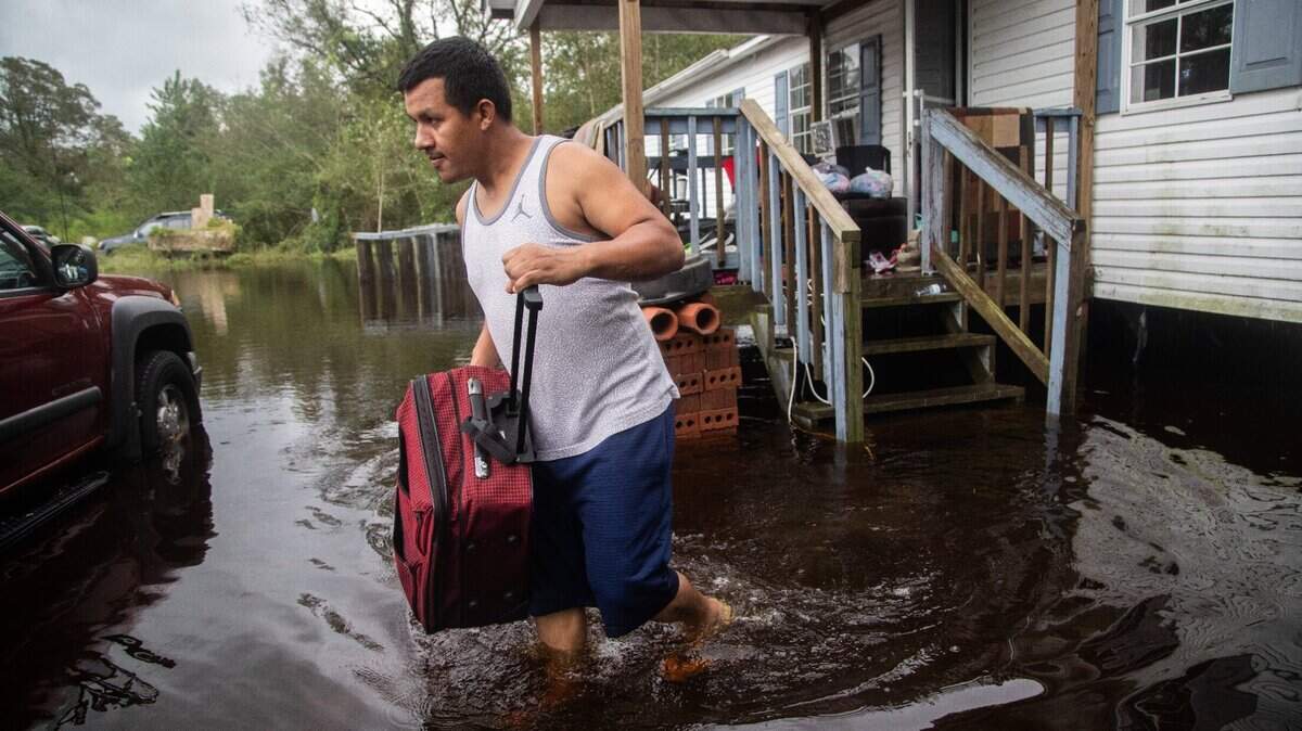 Chavez Gallegos, 24, helps his family move out of a flooded home in Kinston, NC in 2018 after Hurricane Florence. North Carolina has experienced increased flooding and intensifying storms in recent years that scientists attribute to climate change.
