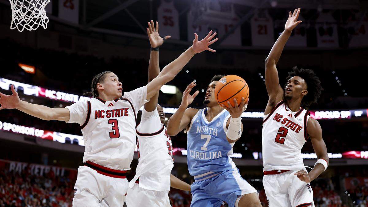 North Carolina's Seth Trimble drives past N.C. State's Matt Able, Ven-Allen Lubin and Paul McNeil in first half action in Raleigh, Tuesday, Feb. 17, 2026.