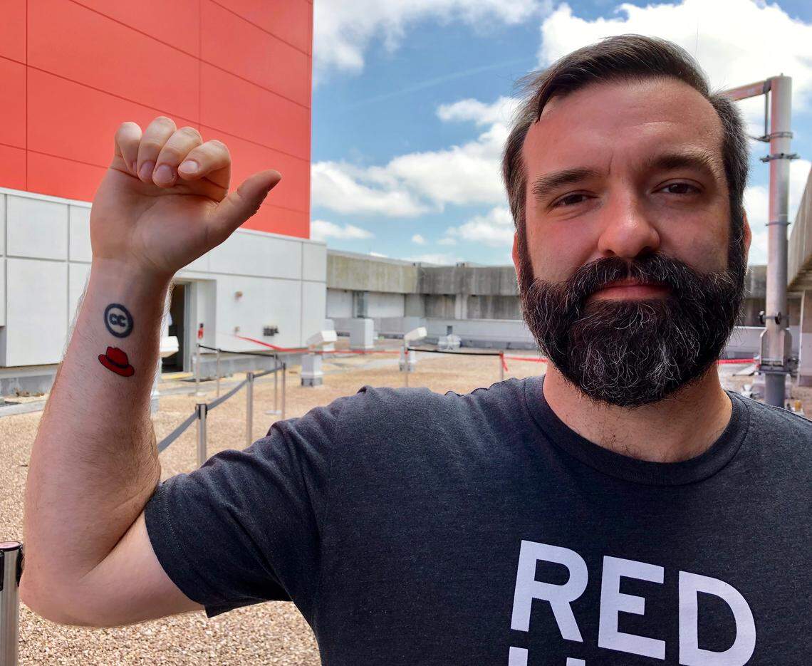 Red Hat employee Colby Hoke, 36, got the new logo tattooed on his arm. “Once I saw (the new logo) on things I loved it. It’s so much cleaner,” he said.