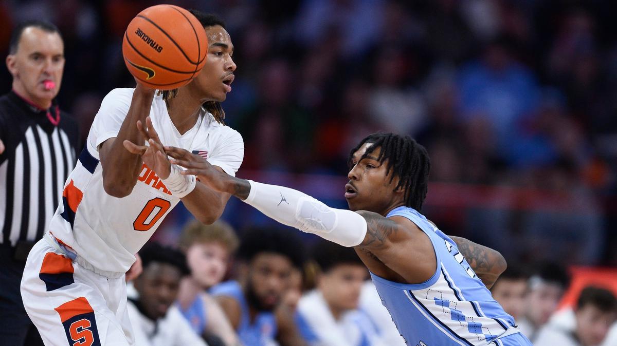 Syracuse forward Chris Bell, left, is defended by North Carolina guard Caleb Love during the first half of an NCAA college basketball game in Syracuse, N.Y., Tuesday, Jan. 24, 2023. (AP Photo/Adrian Kraus)