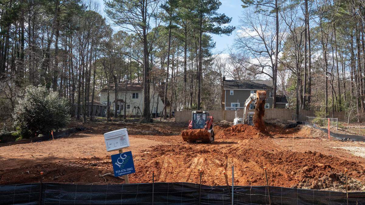 A compact track loader and a back hoe work the lot after the original house was torn down at 7817 Audubon Drive in North Raleigh, NC Feb. 23, 2026.